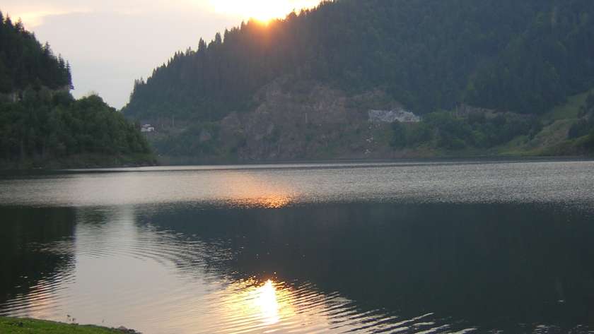 Lacul Colibița la apus, cu apa și versanții împăduriți din Bistrița-Năsăud